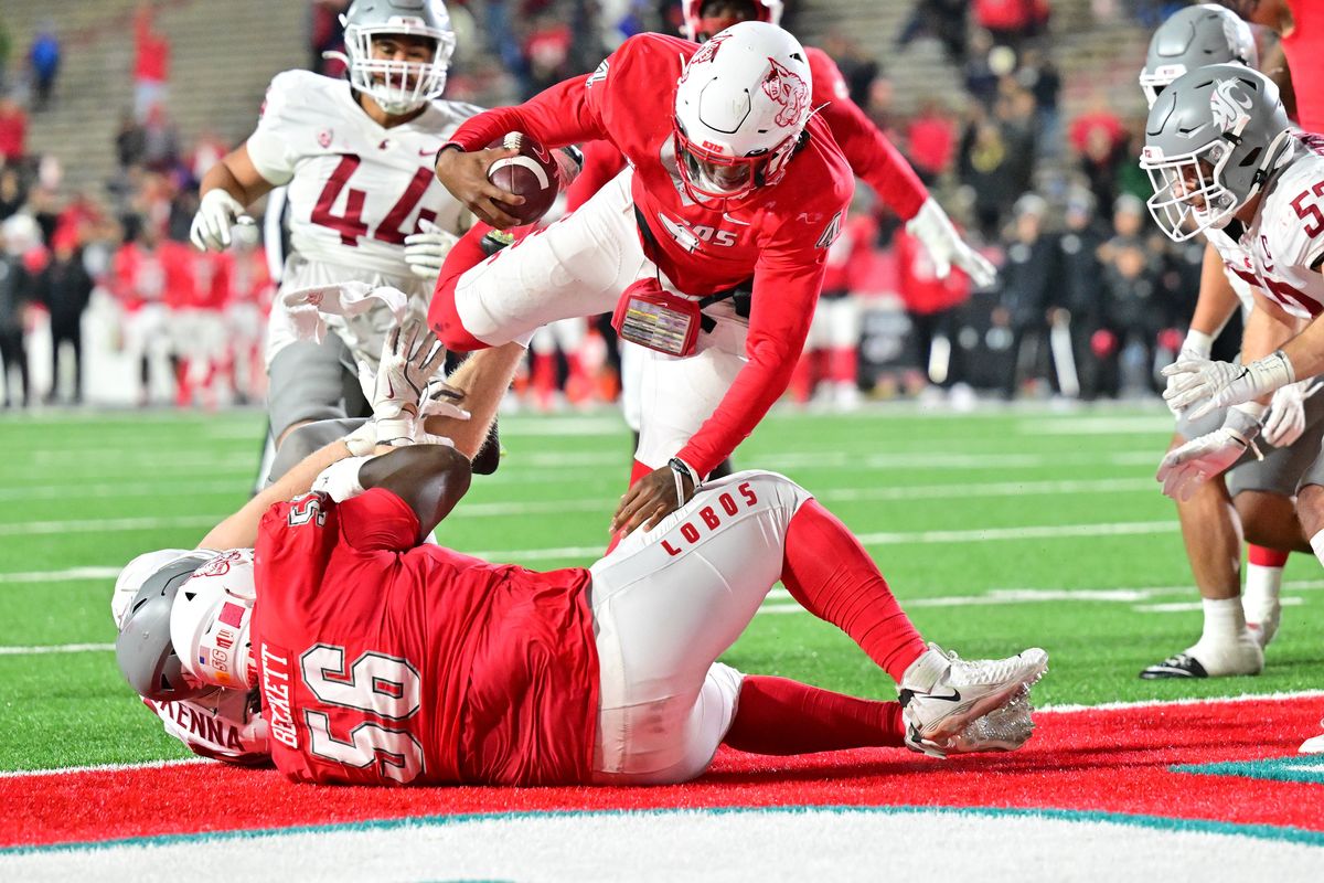 New Mexico Lobos quarterback Devon Dampier leaps into the endzone to score the go-ahead touchdown agianst WSU on Saturday at University Stadium in Albuquerque, N.M. New Mexico won the game 38-35. 