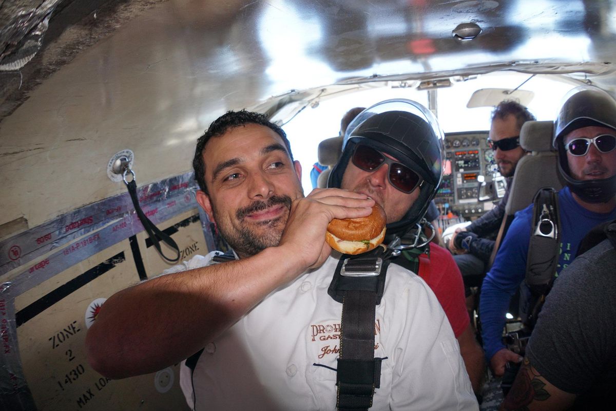 John "J.D." Leonetti shares a bite of his Voot Burger with his skydiving instructor just before a tandem dive Sunday with Skydive West Plains. (Courtesy of Skydive West Plains)