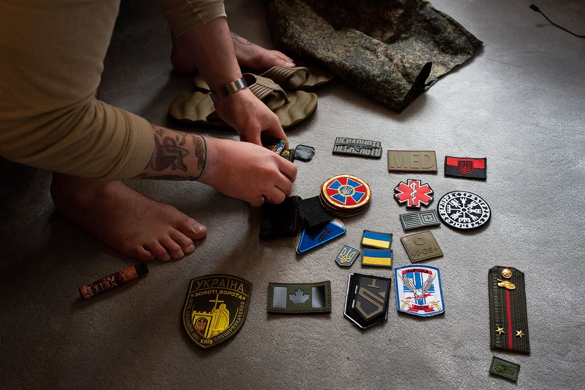 Chris Warren arranged patches he received from Ukrainian military units after returning from Ukraine on April 27, 2022. Warren spent nearly two months in Ukraine fighting for the Ukrainian military.  (Eli Francovich/The Spokesman-Review)