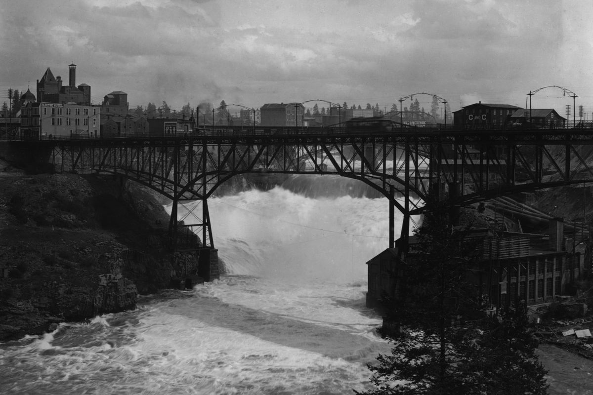 The steel Monroe Street Bridge, built in 1891 and seen here in 1905, carried streetcars, horse-drawn wagons and pedestrians, but users said it vibrated badly when the heavy streetcars went across. It was dismantled in 1910 and the new concrete span opened in 1911. Also in this photo, the original Washington Water Power powerhouse, at lower right, two flour mills and the largest brewery in Spokane at the time. (THE SPOKESMAN-REVIEW PHOTO ARCHIVE / The Little Art Studio)