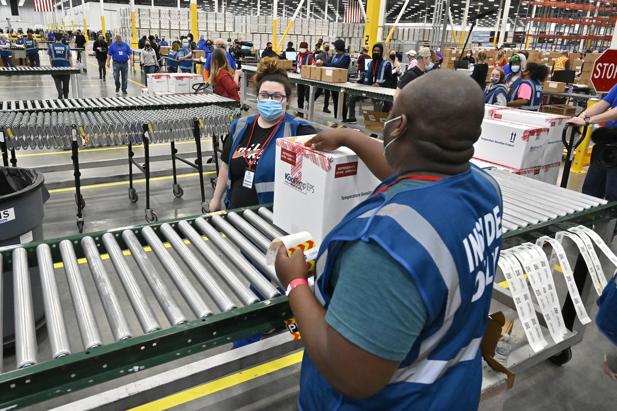 The first box containing the Johnson & Johnson COVID-19 vaccine heads down the conveyor belt to an awaiting transport truck Monday at the McKesson distribution center in Shepherdsville, Ky. (Timothy D. Easley/Associated Press)