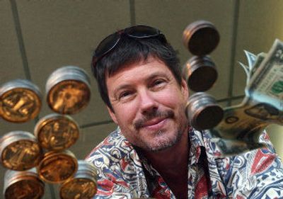 
Store manager Jeff Howard displays the silver coins, Bicentennial coins and $2 bills that were buried under roofing nails in a donated Tang can. 
 (Liz Kishimoto / The Spokesman-Review)
