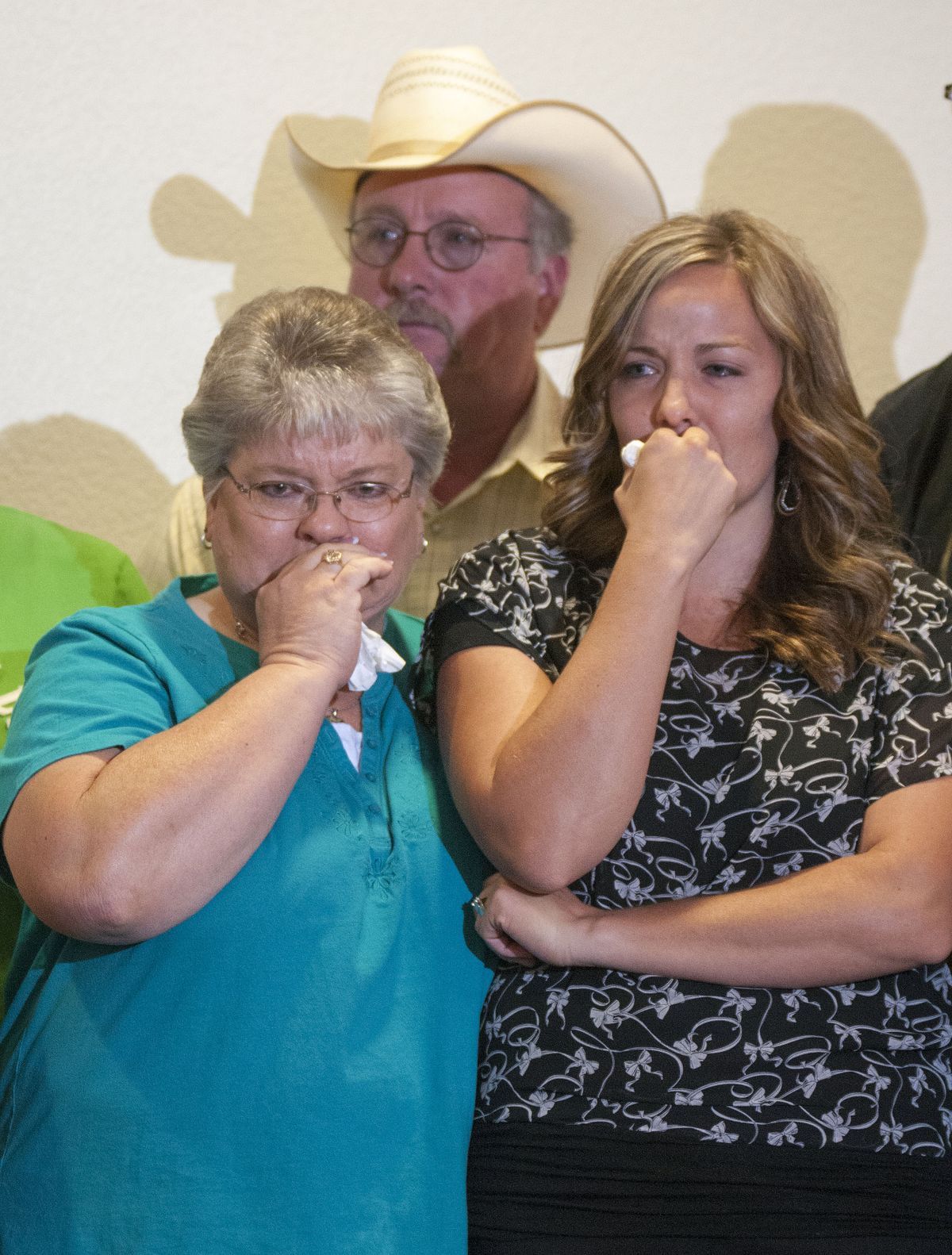 Christy Ivie, right, the wife of slain Border Patrol agent Nicolas Ivie, holds back tears as she stands with her father, Tracy Morris and  her mother DeAnn Morris, at a  news conference  Thursday, Oct. 4 , 2012,  at the Cochise College in Sierra Vista, Ariz. Nicholas Ivie was gunned down Tuesday, Oct 2, as he responded to a tripped sensor on the USA side of the border fence, near the small border town of Naco, Ariz. Ivie