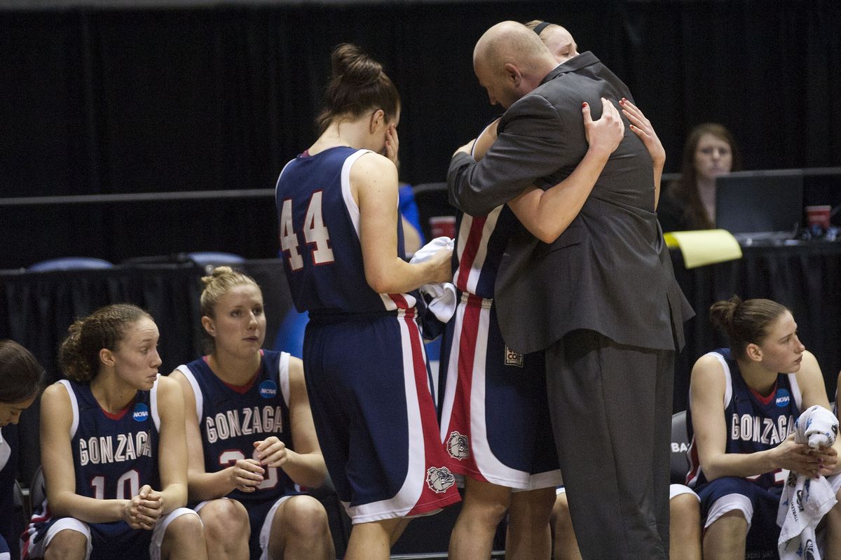 Seniors Kelly Bowen (44) and Kayla Standish hug Gonzaga coach Kelly Graves in the waning moments of their Sweet 16 loss. (Colin Mulvany)