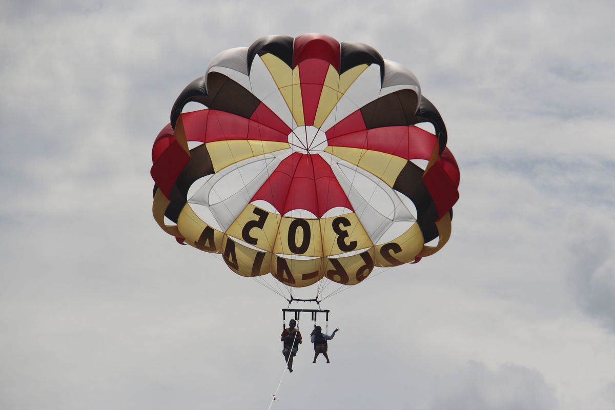 In this Sept. 24,2012 photo, two people parasail over the Miami Beach, Fla. area. Soaring high above the ocean off South Beach, tethered only by a rope to a boat hundreds of feet below, riding in a parasail is at once exhilarating and oddly peaceful, even quiet. For millions of people, that's the takeaway from a once-in-a-lifetime experience. But every year there are accidents, some of them fatal. The Parasail Safety Council, which tracks injuries and deaths from the activity nationwide, reports more than 70 people have been killed and at least 1,600 injured between 1982 and 2012, out of an estimated 150 million parasail rides during those 30 years. Despite the inherent risk, few federal or state safety regulations exist for parasailing. In Florida, which has by far the largest number of parasail operators at about 120, repeated efforts to enact new rules following fatal accidents have landed with a thud. Florida is seen by safety proponents as a national bellwether because of parasailing's popularity in the state. (Tony Winton / Associated Press)