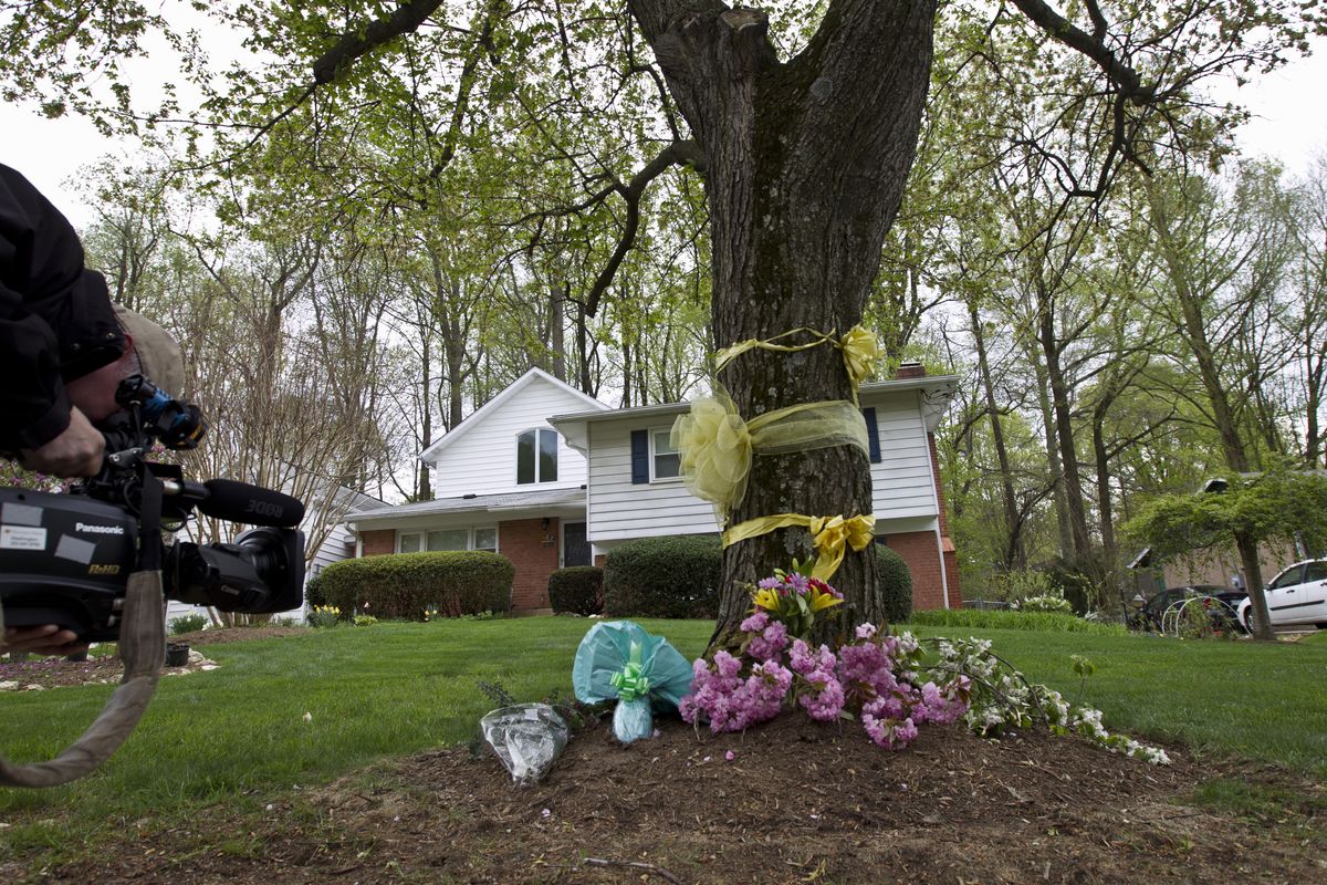 A cameraman photographs flowers and ribbon on a tree outside the Weinstein family house in Rockville, Md., Thursday. Warren Weinstein, of Rockville, was killed by CIA drone strikes early this year. (Associated Press)