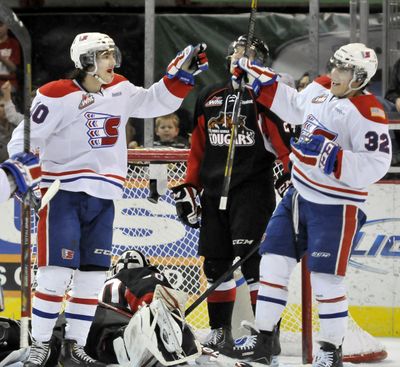 The Spokane Chiefs' Blake Gal (10), left, and Todd Fiddler (32), right, celebrate after Fiddler scores against defender Michael Mylchreest (cq), center, and goalie Mac Engel, a former chief, Tuesday, Mar. 12, 2013 at the Spokane Arena.  Engel was pulled after allowing four goals by the Chiefs in the first two periods. (Jesse Tinsley / The Spokesman-Review)