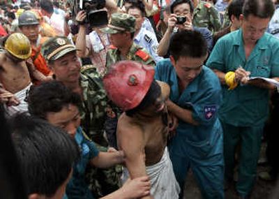 
A rescuer helps carry a miner after he and 68 others were rescued from  a flooded coal mine in Shanxian, China, Wednesday. Associated Press
 (Associated Press / The Spokesman-Review)