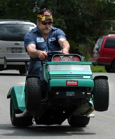 
With a rev of the engine, Mike Chapman shows how his highly modified lawn mower can pop a wheelie from a standing start on Spirit Lake's Maine Street on Friday. Chapman and other competitors will show off their machines and race at the Big Back-In, Spirit Lake's annual lawn mower racing event, on Sunday.
 (Jesse Tinsley / The Spokesman-Review)