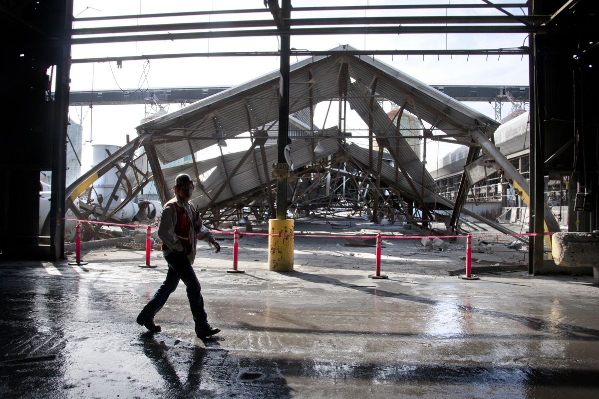 A demolition worker glides past the fallen roof of a pot line room in September 2013 at the old Kaiser Aluminum smelter in Mead during demolition. Groundwater contamination from the plant, which was built in 1942,  lingers beneath the soil in a forested area off Highway 2, and environmental officials have come up with a new plan to treat it. (Dan Pelle / The Spokesman-Review)