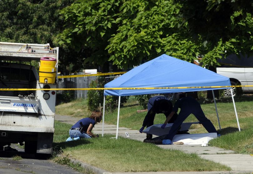 Investigators from the Spokane Police Department and the Spokane County Sheriff's Department examine the scene and cover the body of a man shot by police Friday, July 10, 2009, in north Spokane.   JESSE TINSLEY jesset@spokesman.com (Jesse Tinsley / The Spokesman-Review)