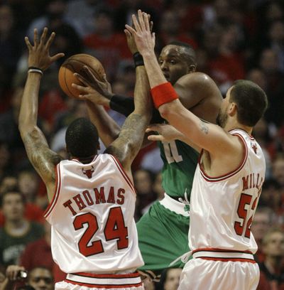 Boston Celtics’ Glen Davis, center, passes the ball between Chicago Bulls defenders Tyrus Thomas  and Brad Miller.  (Associated Press / The Spokesman-Review)