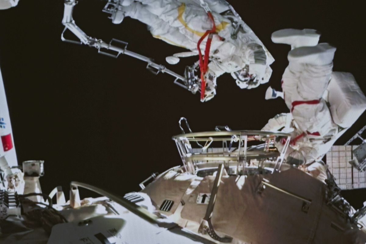In this image released by the Xinhua News Agency, a photo taken on a screen shows Chinese astronauts Zhai Zhigang and Wang Yaping conducting extravehicular activities outside the space station