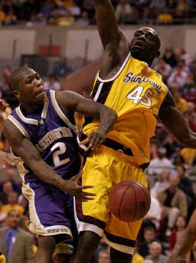 
Washington guard Nate Robinson, left, loses control of the ball after colliding with Arizona State forward Serge Angounou on Sunday. 
 (Associated Press / The Spokesman-Review)