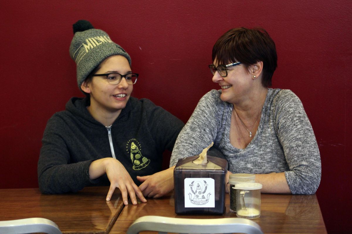 In this Jan. 9, 2017, photo, Andrea Ledesma, left, talks with her mother, Cheryl Romanowski, at Classic Slice pizza restaurant, where Ledesma works, in Milwaukee. Ledesma, 28, says her parents owned a house and were raising kids by her age. Not so for her, even though she has a college degree. With a median household income of $40,581, millennials earn 20 percent less than boomers did at the same stage of life, despite being better educated, according to a new analysis of Federal Reserve data by the advocacy group Young Invincibles. (Carrie Antlfinger / AP)