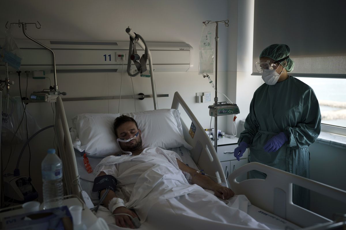 A COVID-19 patient receives treatment in the Hospital del Mar in Barcelona, Spain, Friday, July 9, 2021. After a brief respite that brought its activity back to pre-pandemic routines, the hospital is once again rearranging staff shifts and moving patients around in its sprawling, seafront facilities to face a new surge of infections. (Felipe Dana)