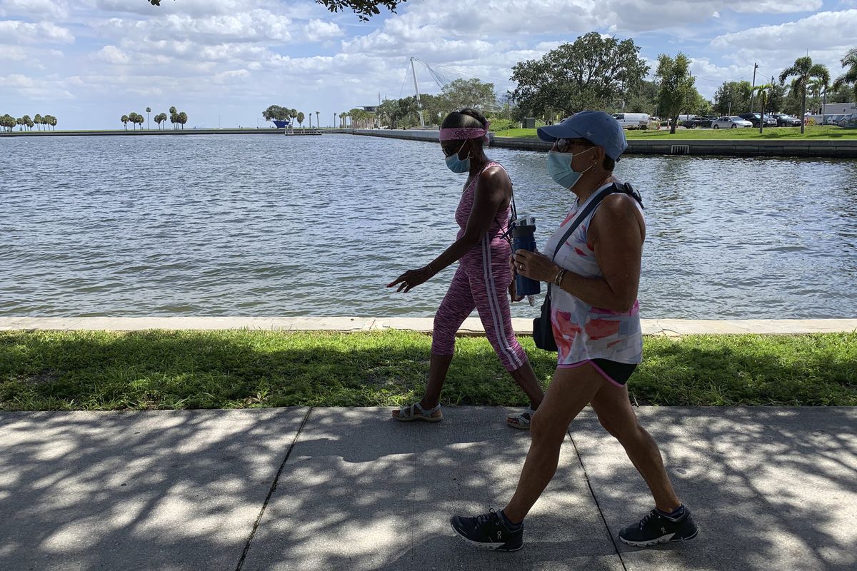 Eva Johnson, left, and Liz Cillo walk along the waterfront in St. Petersburg, Fla., Wednesday, Sept. 23, 2020. Trump recently said that COVID-19 was seriously affecting “virtually nobody” under the age of 18 and sought to frame the pandemic as largely impacting older Americans, as he argued for school districts to resume in-person learning. “We’re dispensable. We’re old. I feel as though he’s never showed any empathy or compassion toward us,” Cillo said.  (Tamara Lush)