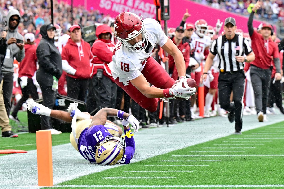 Washington State Cougars wide receiver Josh Meredith (18) leaps past Washington Huskies defensive back Dyson McCutcheon (21) and scores a touchdown during the second half of a college football game on Saturday, Sep. 14, 2024, at Lumen Field in Seattle, Wash. WSU won the game 24-19.  (Tyler Tjomsland/The Spokesman-Review)