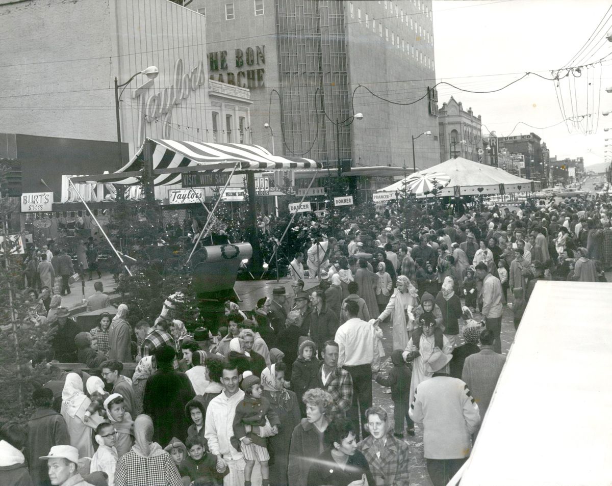 1960: Hundreds of early holiday merrymakers filled Main Avenue outside the Bon Marche department store and other businesses in the downtown shopping district and await the arrival of Santa Claus on Nov. 19, 1960. The event was called the Great Big Downtown Santa Claus Party and had replaced what had been a Christmas parade in previous years. This event and many others since the 1920s had been organized by the Retail Trade Bureau, which decorated the streets, held events and organized retail store hours.  (Spokesman-Review Photo Archives)