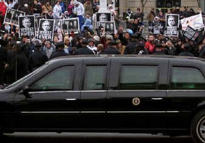 
President Bush's limousine passes protesters assembled along the parade route during the inaugural parade in Washington on Thursday.
 (Reuters / The Spokesman-Review)