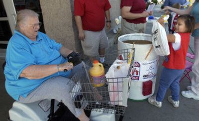 
Samantha Burger, age 5, deposits a shopping bag with school supplies donated by Barbara Bumgarner, left, into a collection barrel at the Shadle Wal-Mart.
 (Dan Pelle / The Spokesman-Review)