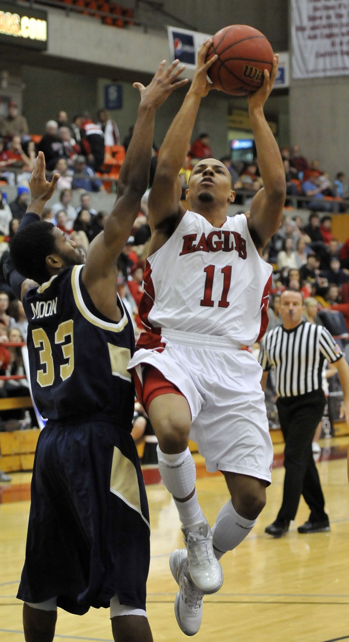 Eastern Washington’s Cliff Colimon drives past Montana State’s Christian Moon for a layup. (Jesse Tinsley)