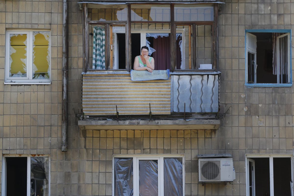 A woman stands on her damaged balcony after morning shelling in Donetsk, eastern Ukraine, on Saturday. (Associated Press)