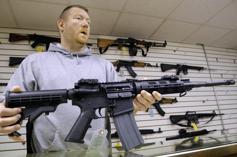 In this Associated Press file photo, John Jackson, co-owner of Capitol City Arms Supply shows off an AR-15 assault rifle for sale at his business in Springfield, Ill. (AP file photo/Seth Perlman)
