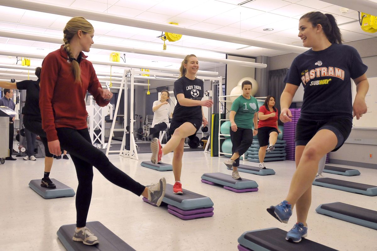 From left, nutrition and exercise physiology student Ali McCoy helps lead a step class as Michelle Timmerman and Rachel Hutchins participate in the free fitness class at the WSU nutrition and exercise physiology program on the Riverpoint Campus. (Jesse Tinsley)