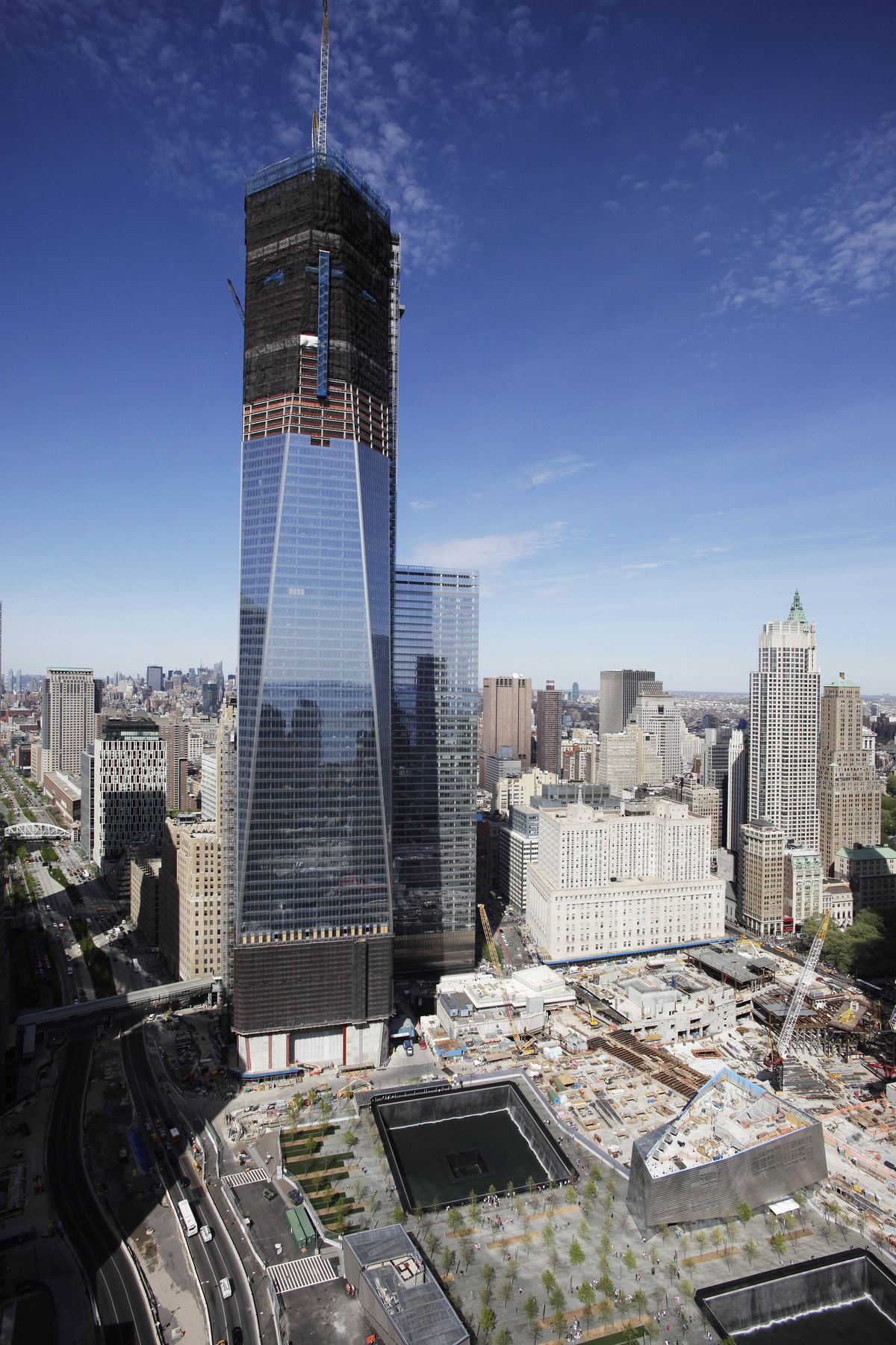 FILE- In this April 17, 2012, file photo, One World Trade Center,  rises above the lower Manhattan skyline and the National September 11 Memorial, lower right, in New York. One World Trade Center, the giant monolith being built to replace the twin towers destroyed in the Sept. 11 attacks, will lay claim to the title of New York City