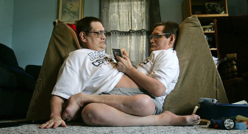 FILE -- In this May 5, 2009 file photo, Siamese twin brothers Ron, left and Don Galyon relax at their home in Dayton, Ohio. They are listed in the Guinness Book of World Records as the oldest living male conjoined twins. Two Ohio men are moving in with their brother Jim in the Spring. (Jim Noelker / Dayton Daily News)