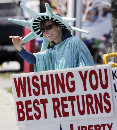 Elaine Scholtz waves at cars in front of Liberty Tax Service in Laconia, N.H., last April. (Associated Press)
