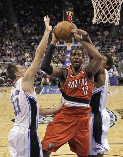 Portland’s LaMarcus Aldridge works his way past Orlando’s Ryan Anderson, left, and Earl Clark for two of his 24 points. (Associated Press)