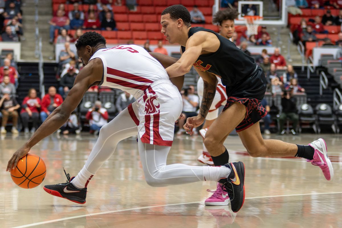 Washington State guard TJ Bamba, left, drives around USC guard Kobe Johnson in the first half on Sunday, Jan. 1, 2023 at Beasley Coliseum in Pullman.  (Geoff Crimmins/For The Spokesman-Review)