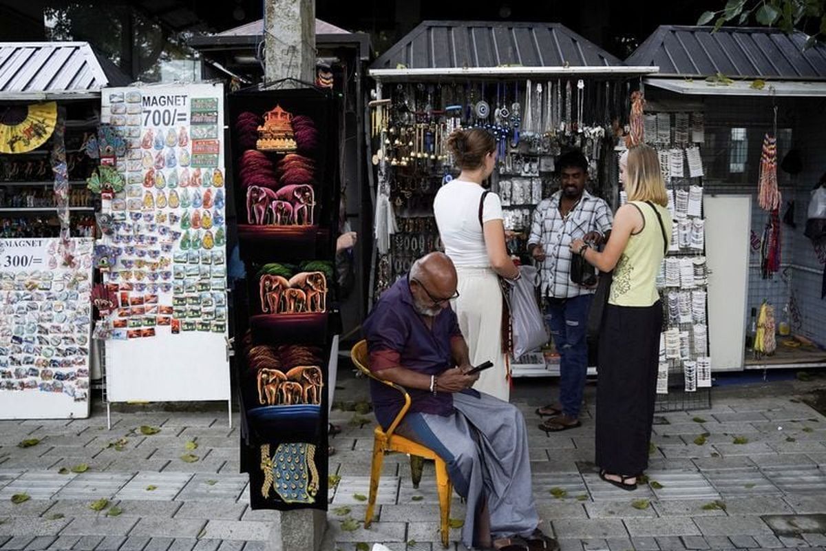 Tourists buy souvenirs from a roadside stall near the Temple of the Tooth, also known as Sri Dalada Maligawa, following Cyclone Ditwah, in Kandy, Sri Lanka, December 4, 2025. REUTERS/Akila Jayawardena (Akila Jayawardena)
