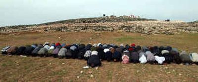 
Palestinians perform their Friday prayers during a demonstration  where Israel is building part of its controversial separation barrier in the southern West Bank. 
 (Associated Press / The Spokesman-Review)