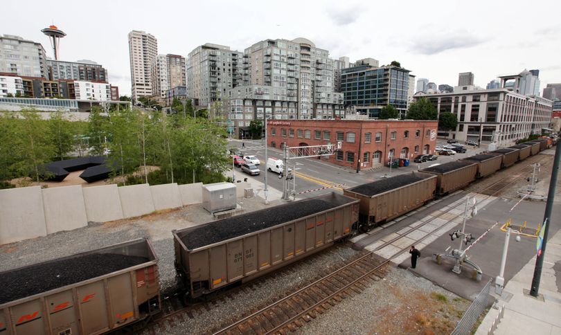 A train hauling coal to British Columbia heads north out of downtown Seattle on Tuesday afternoon. The Seattle City Council has unanimously passed a resolution opposing the development of coal-export terminals in Washington state. (Associated Press)