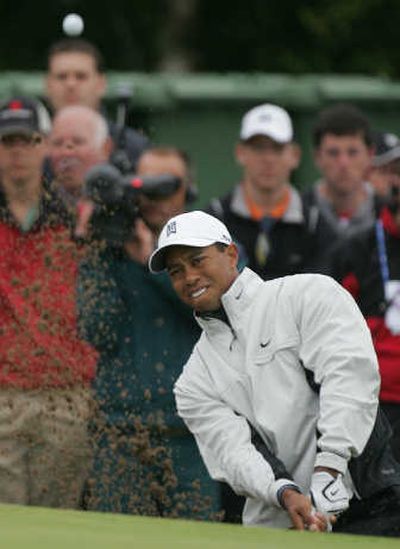 
Associated Press Tiger Woods plays from a bunker near the 8th green on Thursday. Two holes later he saved a stroke, thanks to a disputed call.
 (Associated Press / The Spokesman-Review)
