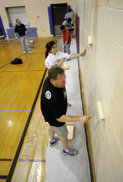 Dan Garske, front,  Megan Nilsson and others paint the gym in Mead’s former middle school. (Colin Mulvany)
