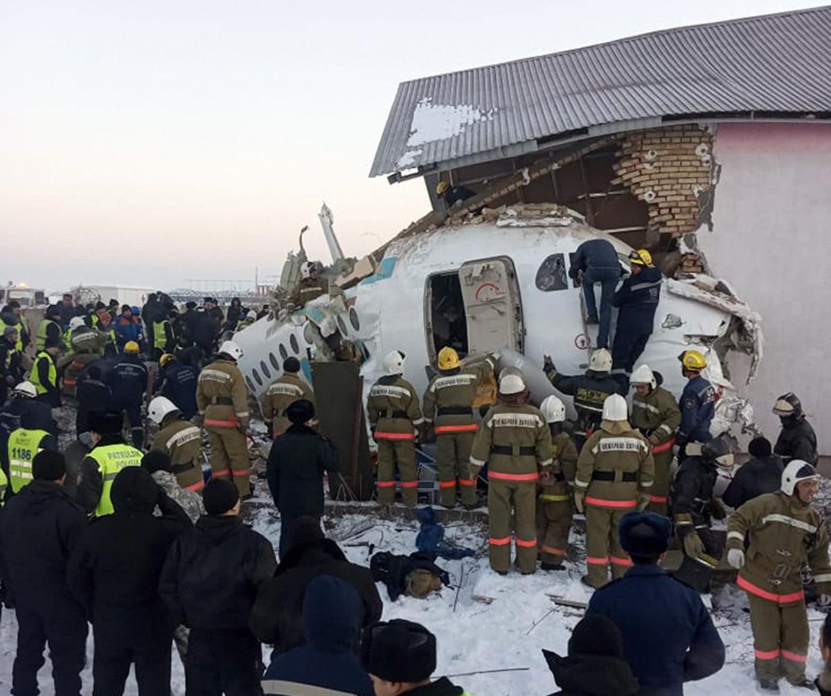 In this handout photo provided by the Emergency Situations Ministry of the Republic of Kazakhstan, police and rescuers work on the site of a plane crash near Almaty International Airport, outside Almaty, Kazakhstan, Friday, Dec. 27, 2019. Almaty International Airport said a Bek Air plane crashed Friday in Kazakhstan shortly after takeoff causing numerous deaths. The aircraft had 100 passengers and crew onboard when hit a concrete fence and a two-story building shortly after takeoff. (Emergency Situations Ministry of the Republic of Kazakhstan photo via AP)