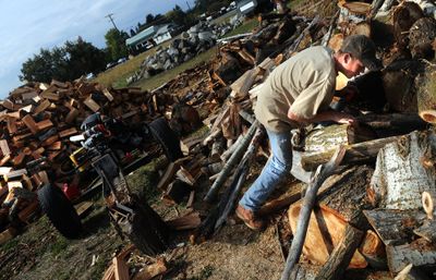 John Redl picks out wood for chopping last week at AK Tree and Landscape in Spokane Valley. (Rajah Bose / The Spokesman-Review)