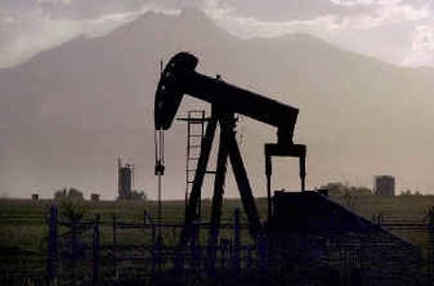 An oil pumper is silhouetted against Long's Peak near Firestone, Colo. in this July 17, 2001 file photo.
(Associated Press / The Spokesman-Review)