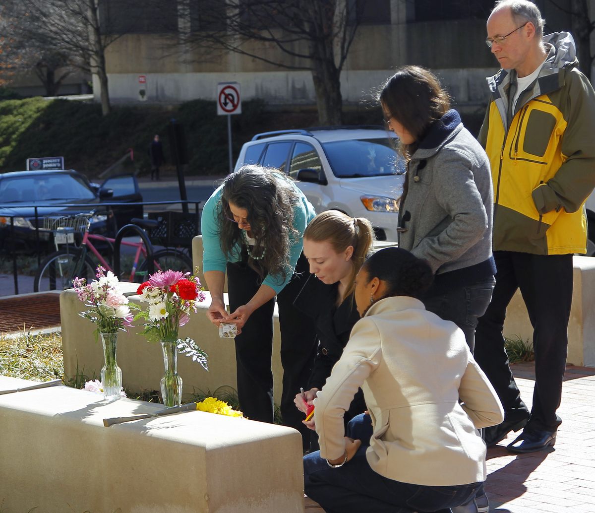 Mourners bring flowers to a makeshift memorial Wednesday outside the University of North Carolina School of Dentistry in Chapel Hill. (Associated Press)