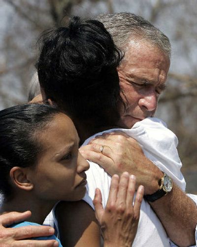 
President Bush tries to comfort Bronwynn Bassier, 23, of Biloxi, Miss., center, and her sister Kim Bassier, 21, on Friday during a walking tour in  Biloxi, which was among Gulf Coast communities devastated by Hurricane Katrina. 
 (Associated Press / The Spokesman-Review)