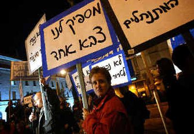 
Israeli activists hold peace banners near the Jerusalem residence of Prime Minister Ariel Sharon on Sunday. The sign in Hebrew reads: 