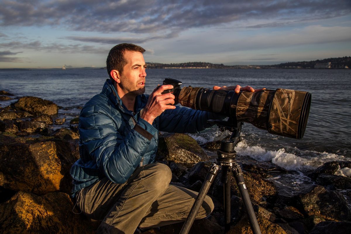Nature photographer Garrit Vyn, of Seattle, looks for shorebirds to photograph at Duwamish Head in West Seattle. (Steve Ringman / The Seattle Times)