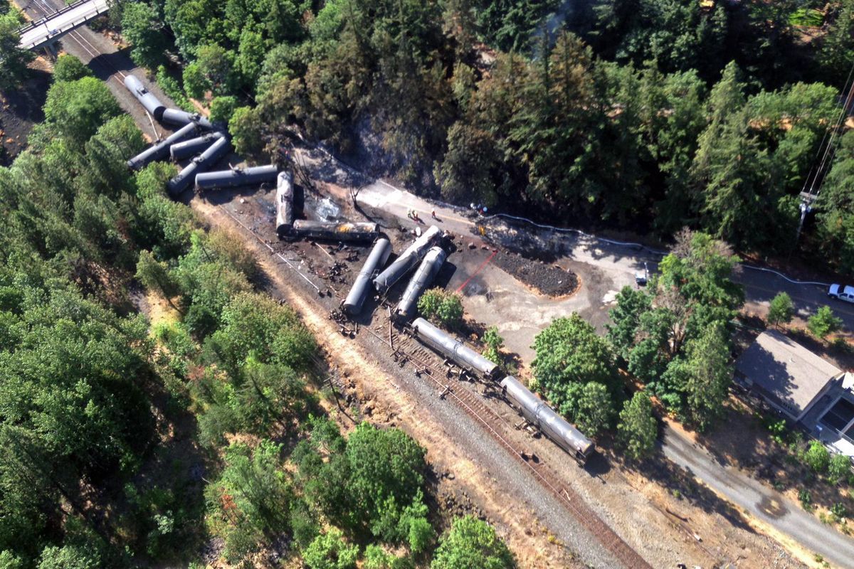 This aerial view provided by the Washington State Department of Ecology shows scattered and burned oil tank cars on Saturday, June 4, 2016, near Mosier, Ore. (Associated Press)