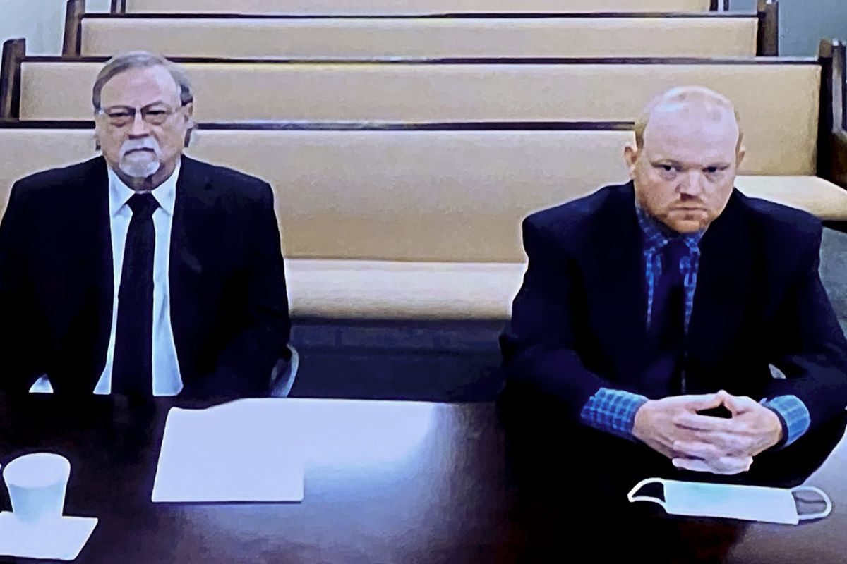 In this image made from video, from left, father and son, Gregory and Travis McMichael, accused in the shooting death of Ahmaud Arbery in Georgia on Feb. 2020, listen via closed circuit tv in the Glynn County Detention center in Brunswick, Ga., on Thursday, Nov. 12, as lawyers argue for bond to be set at the Glynn County courthouse. The McMichaels chased and fatally shot Ahmaud Arbery, a 25-year-old Black man, after they spotted him running in their neighborhood just outside the port city of Brunswick. (Lewis Levine)