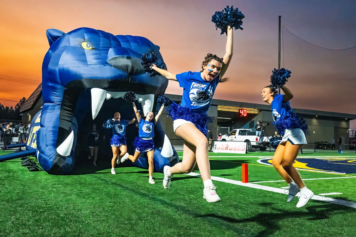 Mead cheerleaders enter the field before the Panther football team on Sept. 26 during the annual Battle of the Bell rivalry high school football game with Mt. Spokane at Union Stadium in Mead.  (COLIN MULVANY)
