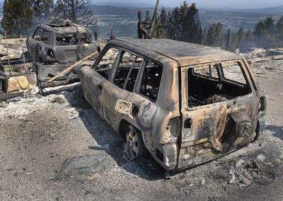 Only shells remained of these vehicles Friday at a burned home on Park Lane in Spokane Valley. A wildfire destroyed 13 homes. (Christopher Anderson / The Spokesman-Review)